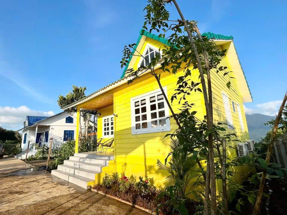 Nhà gỗ sơn vàng dưới nắng sớm ở Tà Đùng